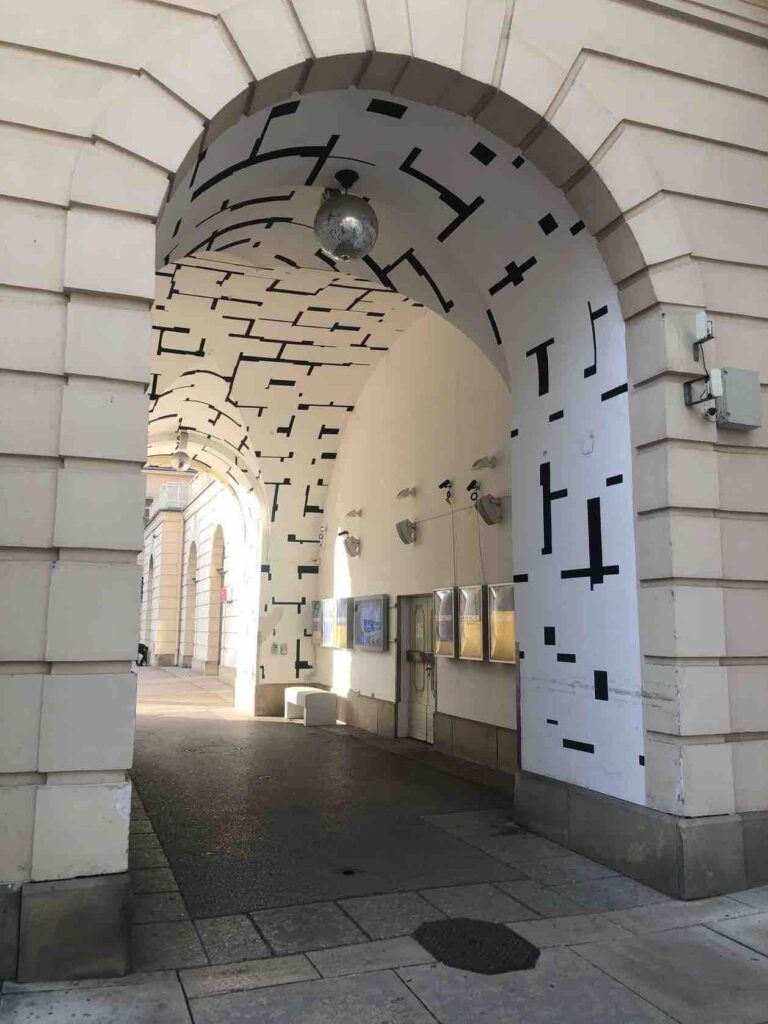 Passage way in old building, painted entirely white with black lines neatly on it in sections