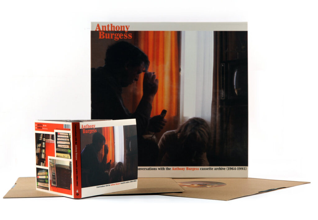 An LP and CD on display, with Anthony Burgess, with an image of people in a room, obscured and in the shade
