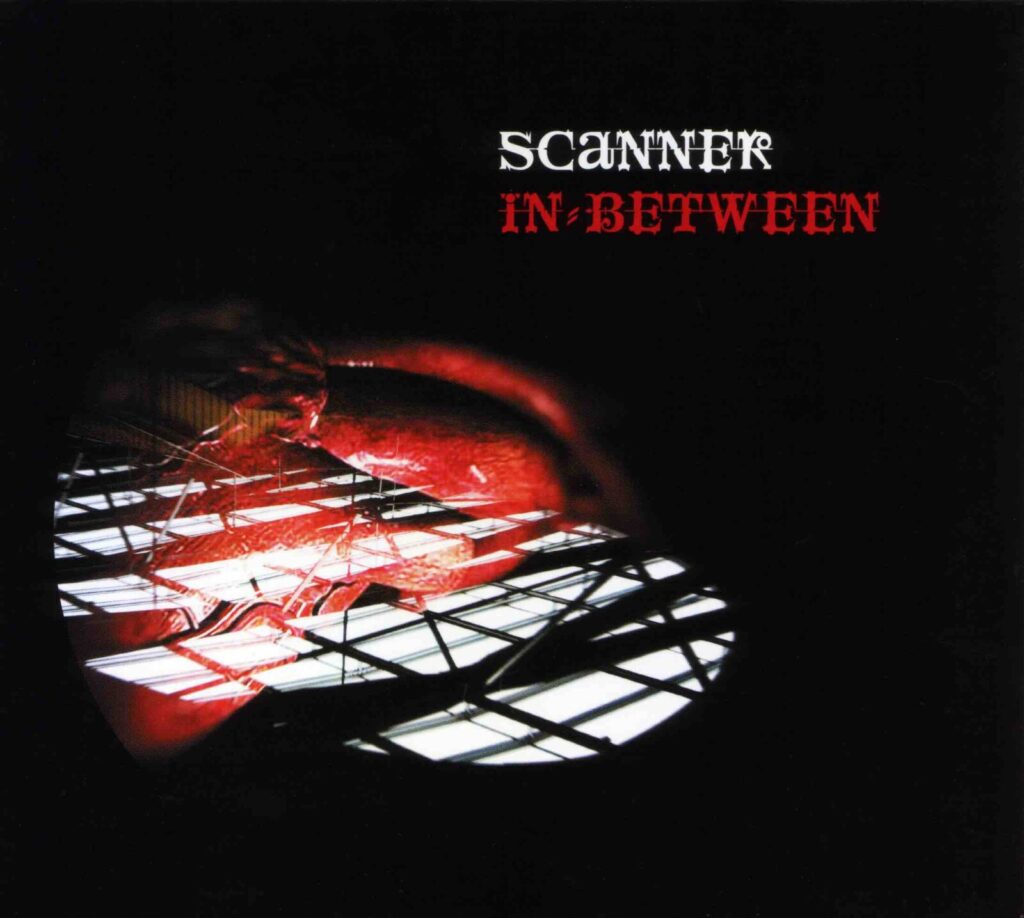 Artwork from a compact disc, with the artist and title IN BETWEEN written in a gothic script, above an image of a red heart set onto a black background