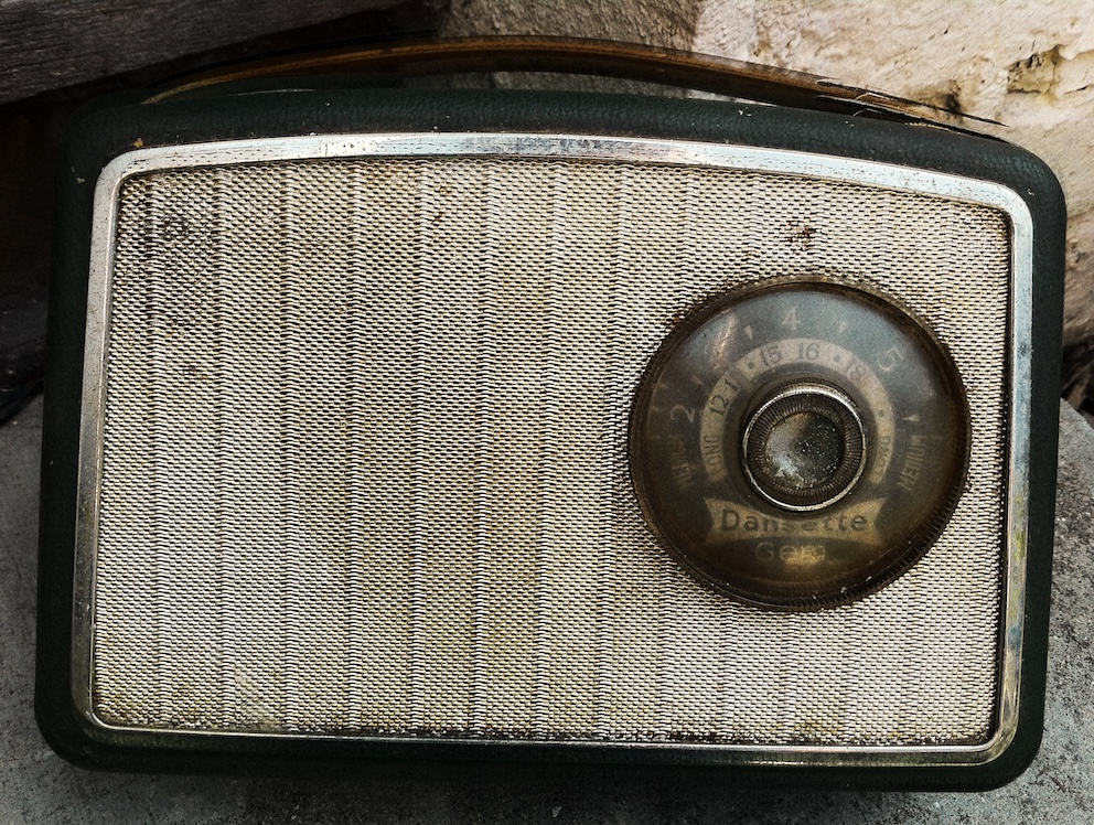 An old Dansette radio from the 150s, a curved dark green dirty radio with large dial on the right side