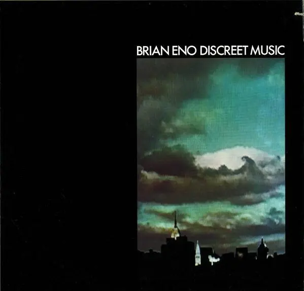 Album cover for Brian Eno Discreet Music with the title featured on the right above an image of a cloudy sky over a city