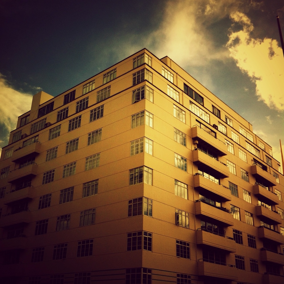 Colourful nostalgic photo of a modernst housing block in London, with a yellow tint to it