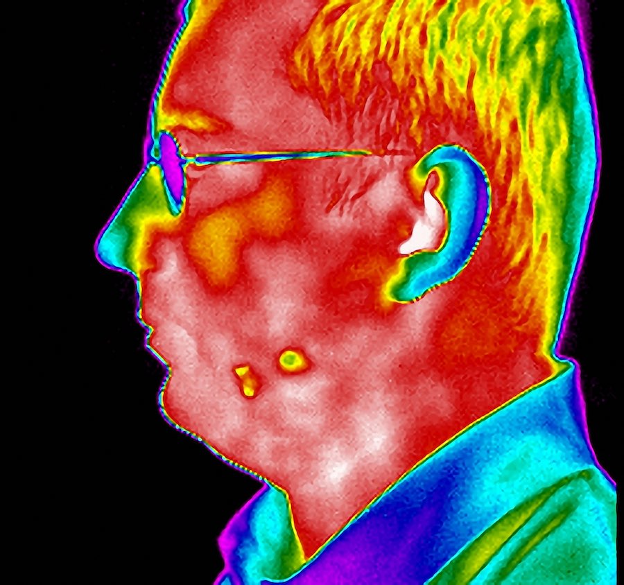A colourful image of an older man, taken from the side profile. He's wearing glasses, with short hair and a shirt. The entire image is processed through a solar lens so it looks quite unusual