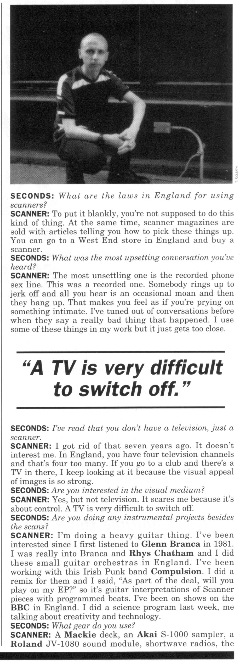 Text interview with Scanner and a photo at the top of a white man crouched down on the ground dressed in a smart striped shirt